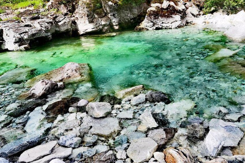 A clear turquoise pool surrounded by rocky terrain. 4