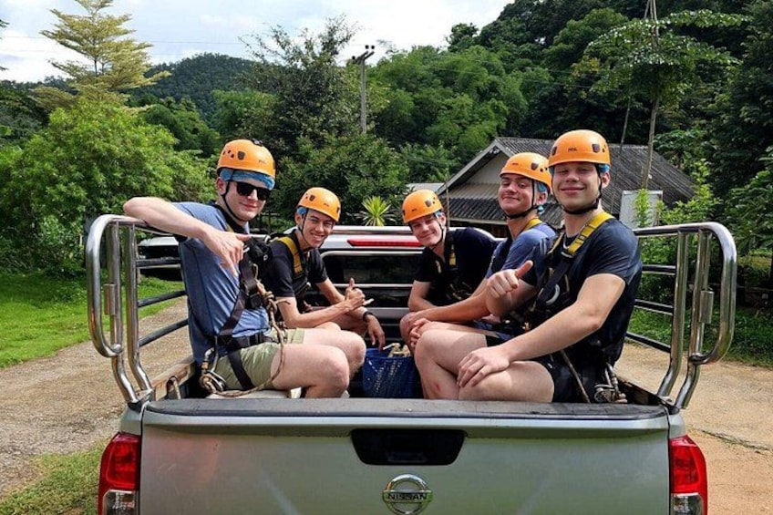 Four people in helmets and harnesses sitting in a vehicle. 2