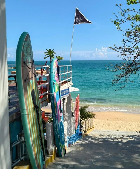 A beachside surf shop with surfboards and a flag. 5