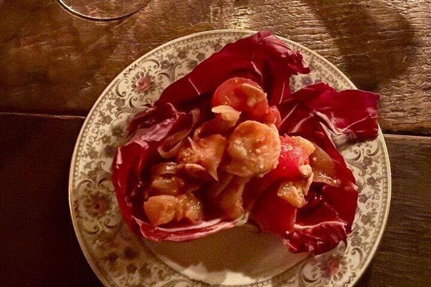 Un plato de comida con col roja y camarones sobre un plato estampado. 4