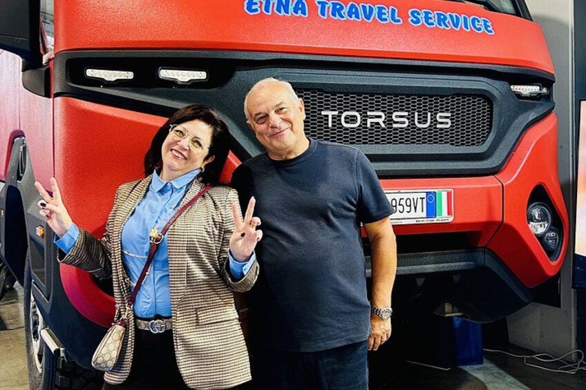 En röd buss med texten ”ETNA TRAVEL SERVICE” och ”TORSUS” målad på sidan. 2