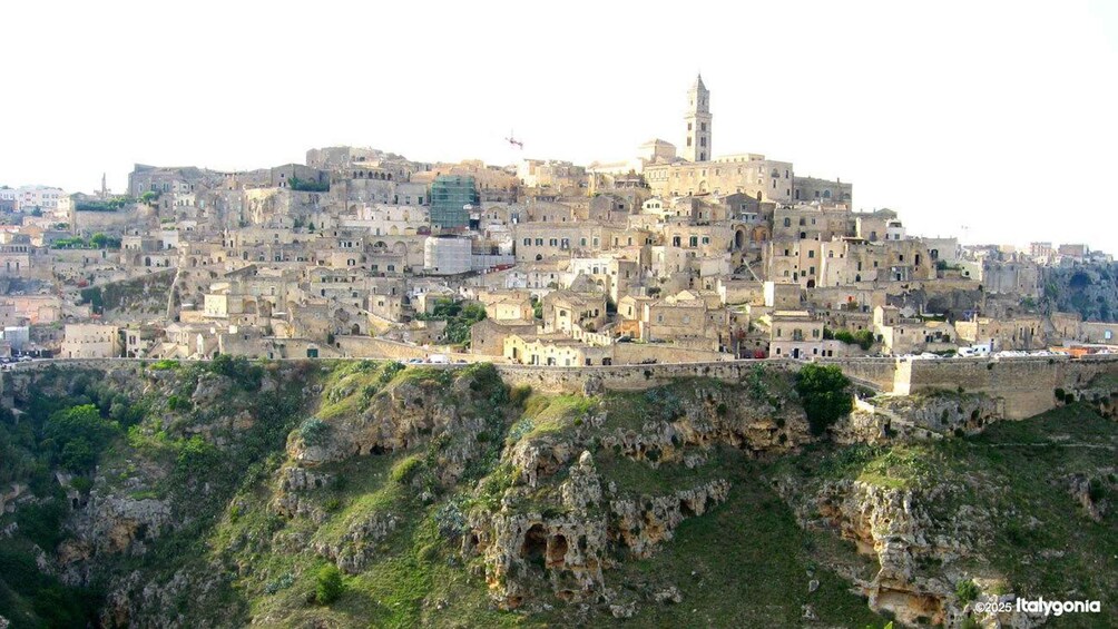 A historic town built on a hillside with a prominent tower. 1