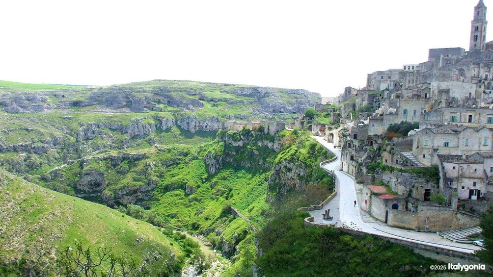 A mountainous landscape with a winding road, green valleys, and historic stone buildings. 3