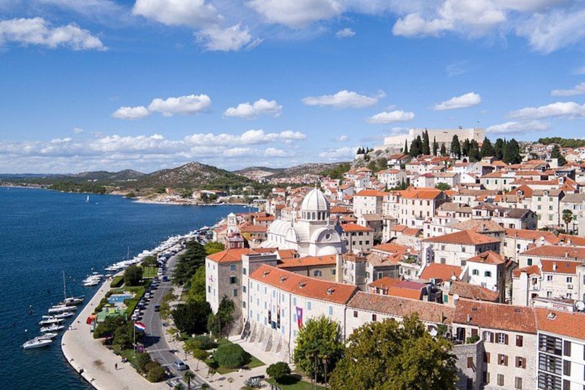 A coastal town with a prominent white church, a marina, and a hilltop fortress. 5