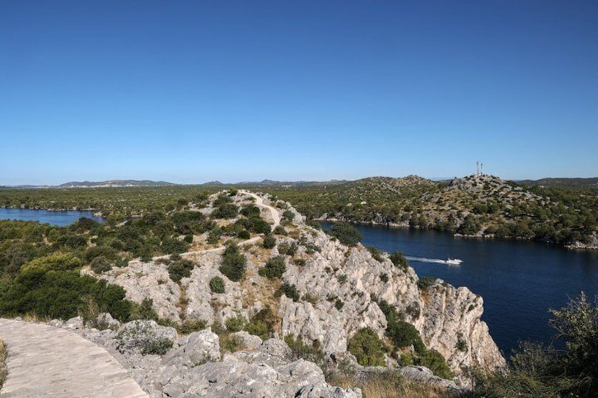 Eine Küstenlandschaft mit felsigem Gelände, blauem Himmel und einem Gewässer. 4