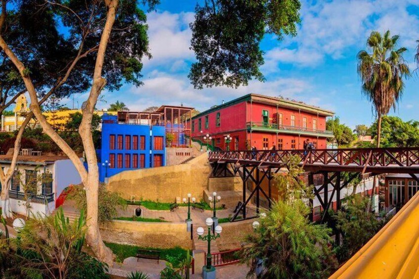A colorful urban landscape with a red building, a blue building, and a yellow bridge. 2