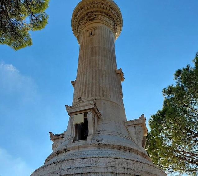 A tall, cylindrical stone monument with intricate carvings and a small opening at the base. 4