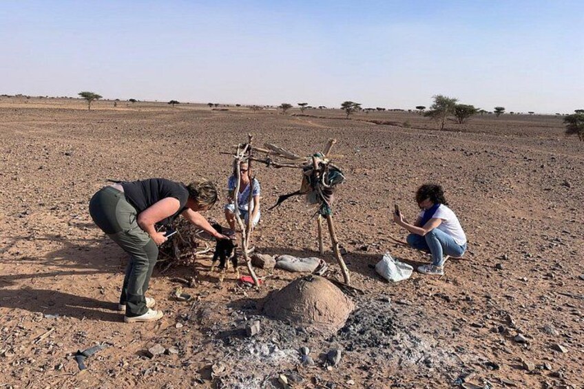 Un grupo de personas en un paisaje árido y abierto, con poca vegetación, realizando una actividad alrededor de una cámara sobre trípode. 3