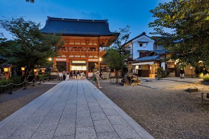 Un edificio japonés tradicional con un sendero adoquinado que conduce a él, rodeado de árboles y un área de grava. 3