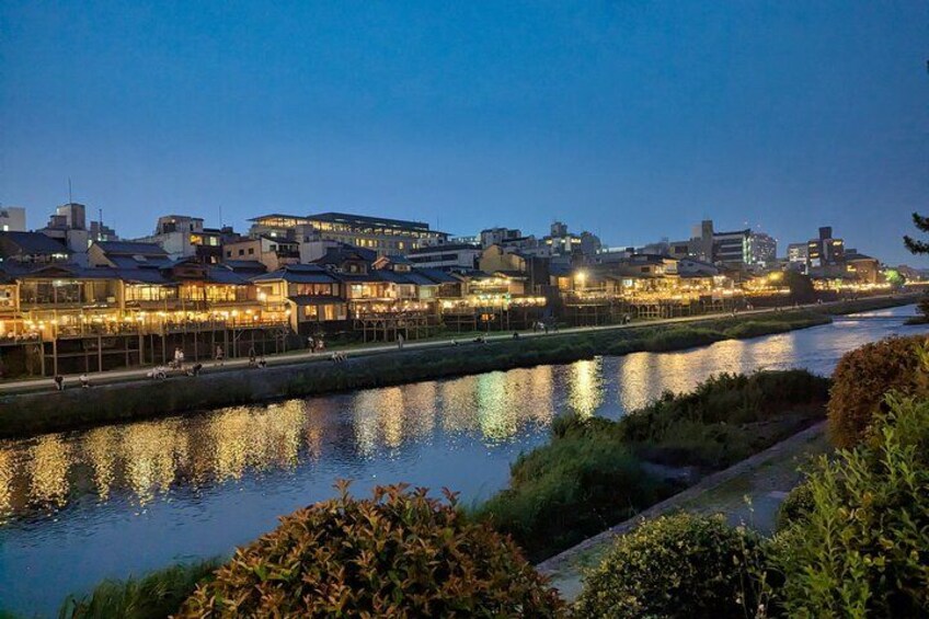 Un río que refleja las luces de la ciudad, un puente y edificios a lo largo de la orilla. 5
