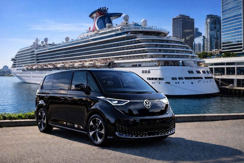 A black Volkswagen car parked in front of a cruise ship. 3