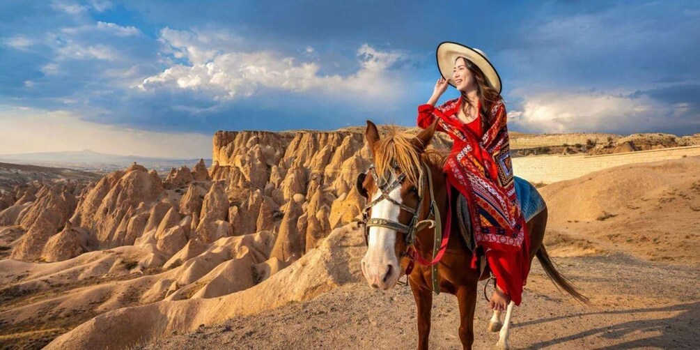 A person riding a horse in a desert landscape with distinctive rock formations. 1