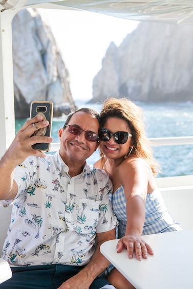 A man and a woman on a boat with rocky cliffs in the background. 5