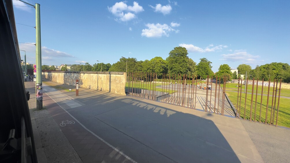 Un parque con una ciclovía, una valla y árboles. 5