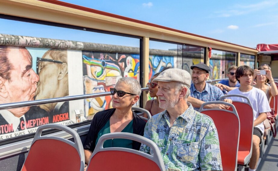Pasajeros en un autobús con un mural en la parte exterior. 3