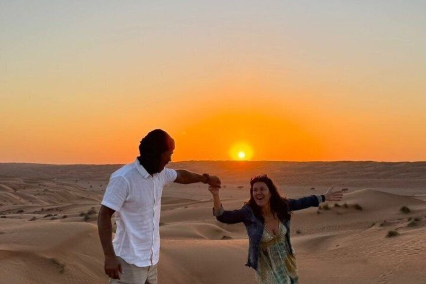 A couple holding hands in a desert at sunset. 4