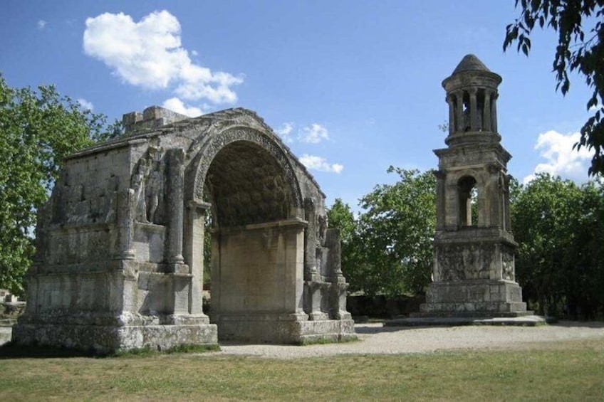 Una estructura de piedra antigua con un arco de entrada y un campanario. 3