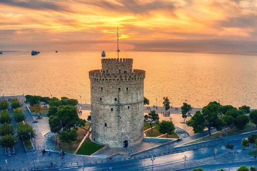 A historic tower by the sea during sunset. 3