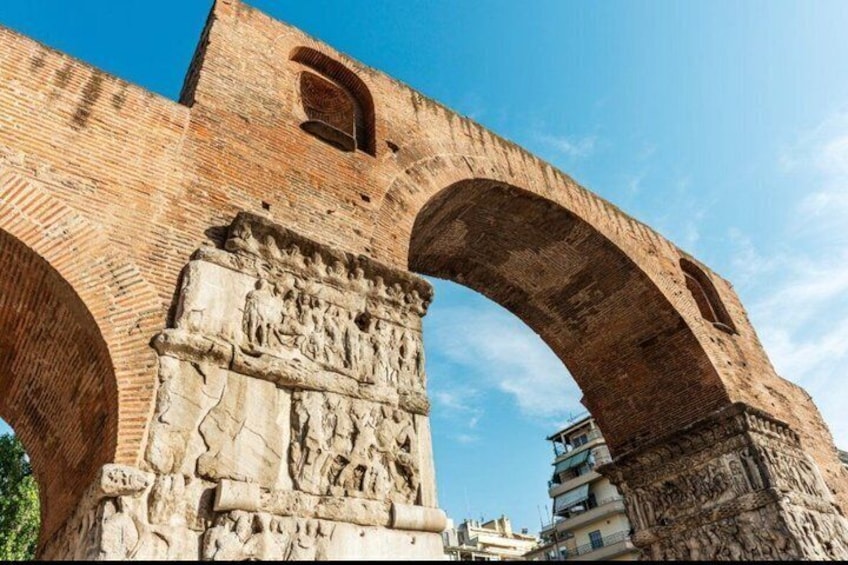 An ancient Roman arch with intricate carvings and a clear blue sky. 4
