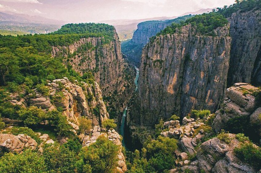 Un cañón con acantilados escarpados, un río y abundante vegetación. 4