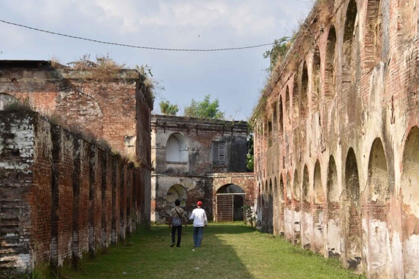 An old brick structure with arches and a grassy pathway. 3