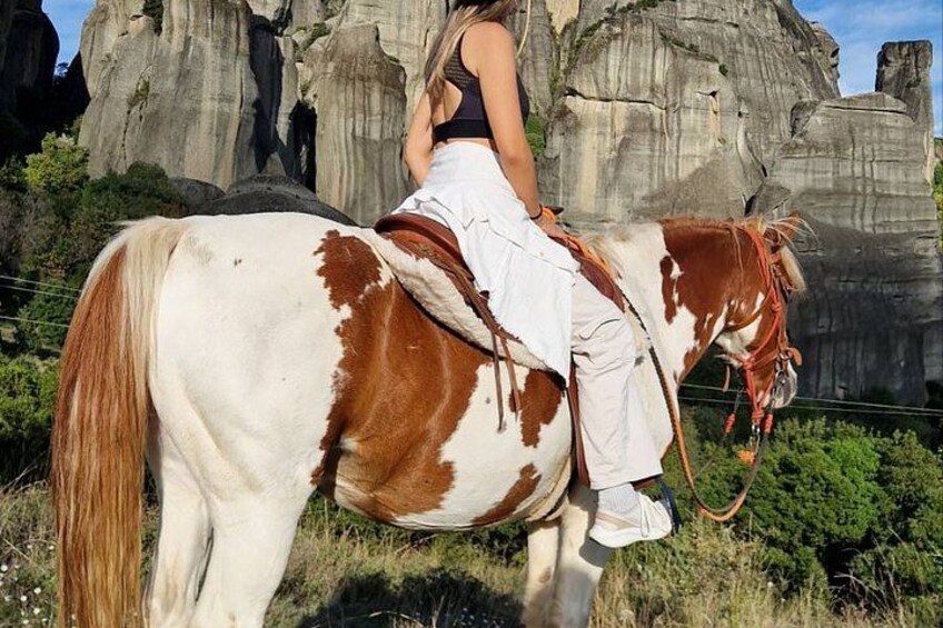 A person riding a horse with a rocky landscape in the background. 3