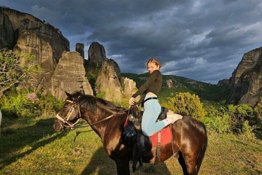 A person riding a horse in a natural landscape with rock formations. 2