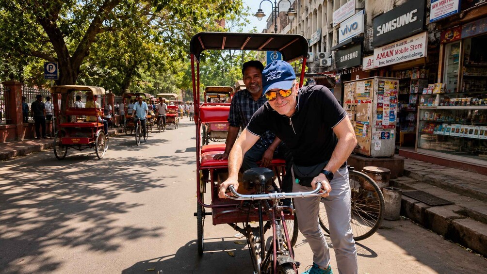 A street scene with rickshaws, shops, and pedestrians. 1