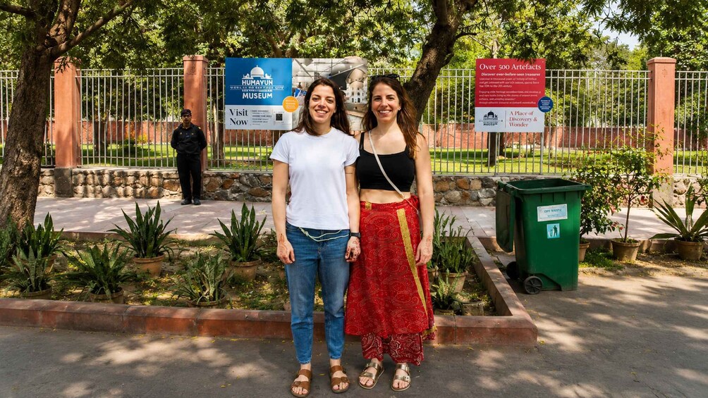 Two people standing in front of a museum with informational signs. 4