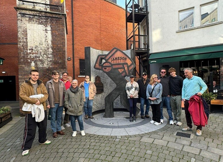 A group of people standing in front of a building with a sign that reads 'Jameson Gallery.' 1