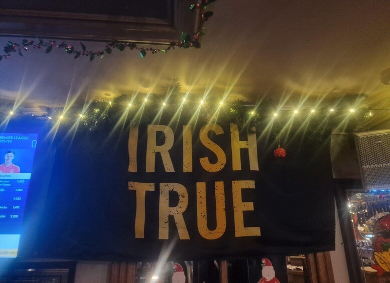 A banner with 'IRISH TRUE' text, surrounded by string lights and festive decorations. 5