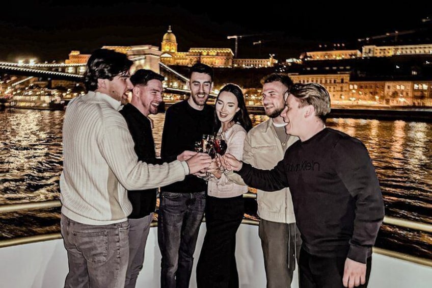 A group of people on a boat with a cityscape and a bridge in the background. 3
