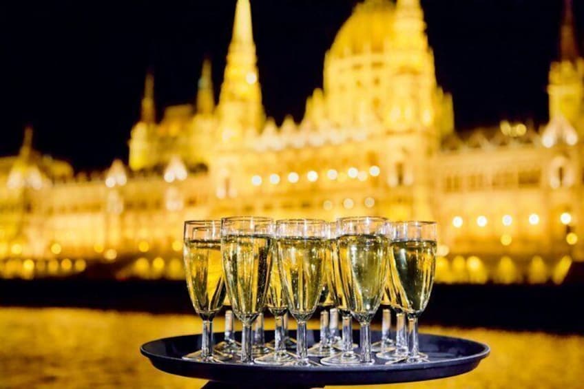 Un plateau de coupes à champagne est posé devant un bâtiment illuminé, la nuit. 2