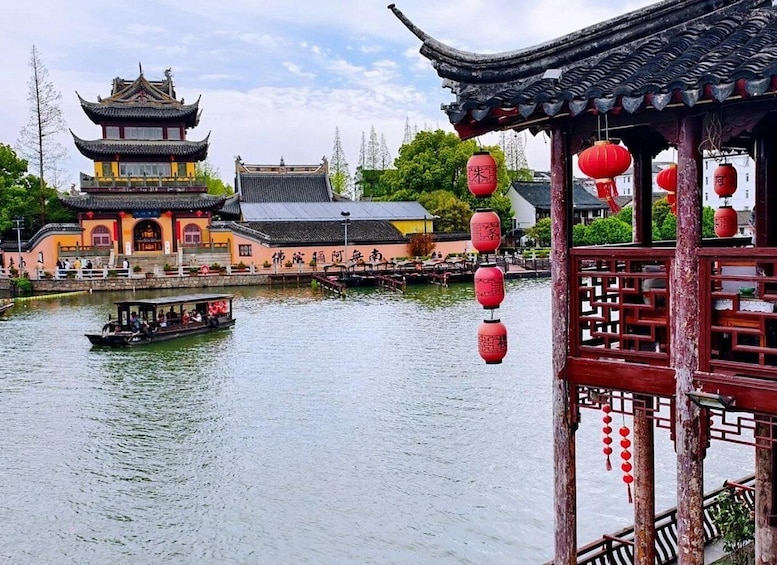 A traditional Chinese building with a boat on the water. 3