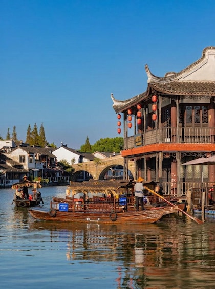 Traditional Chinese architecture, a river with boats, and a clear blue sky. 1