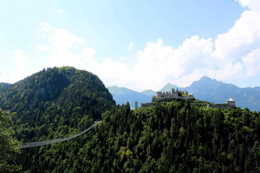 A castle on a hilltop with a suspension bridge. 4