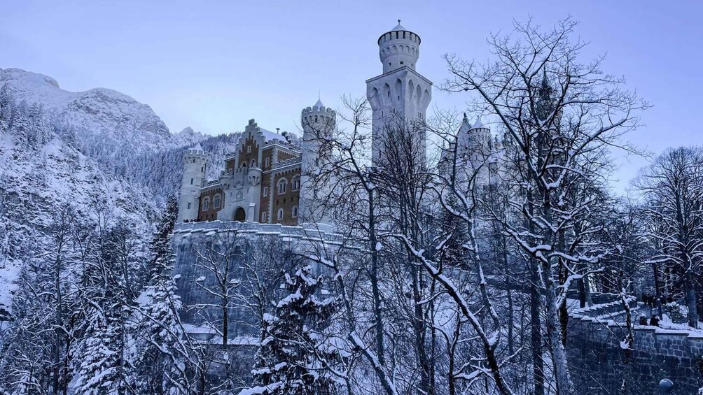 A snow-covered castle with multiple towers and a surrounding forest. 5