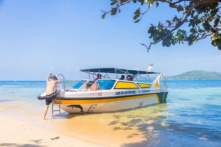 Un bote llamado 'Cano do Lago Puro' sobre una playa arenosa con agua cristalina y una montaña distante. 1