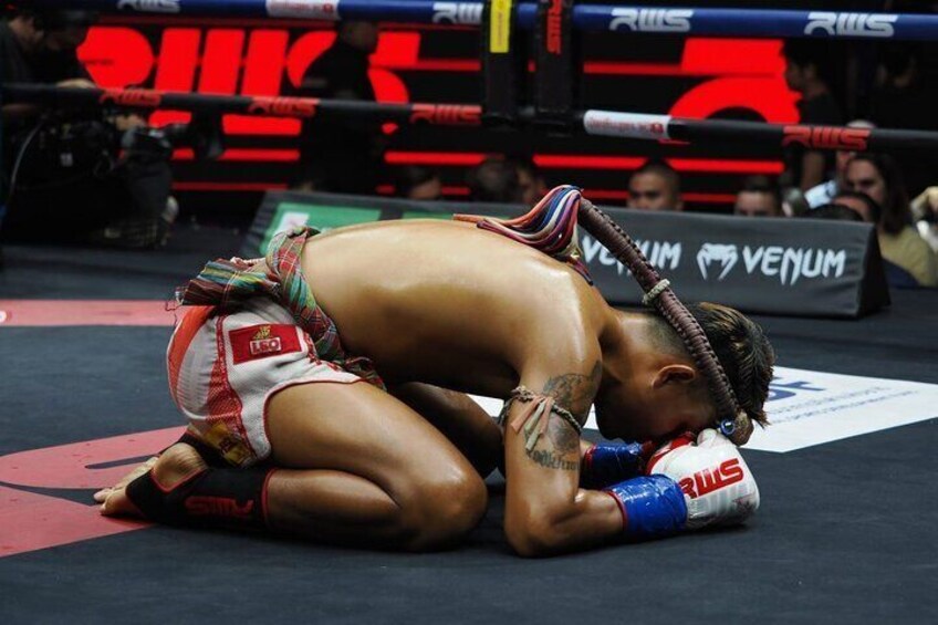 A wrestling match with one wrestler on the ground and another on top. 3