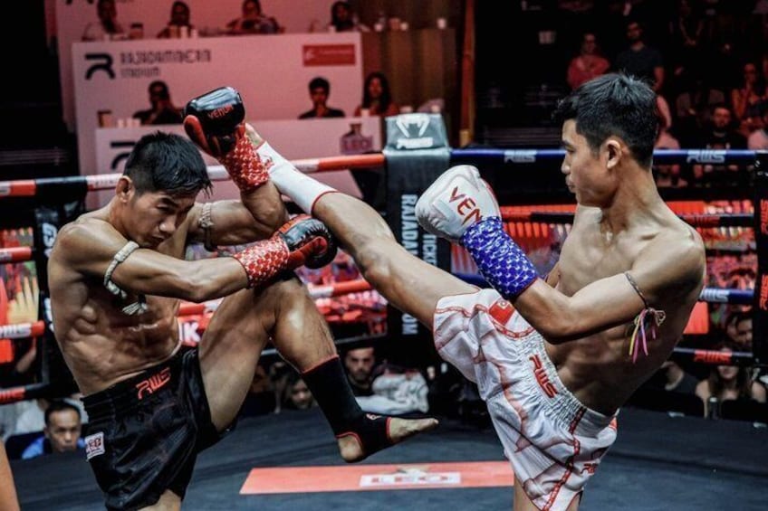 A boxing match in a ring with a crowd in the background. 1