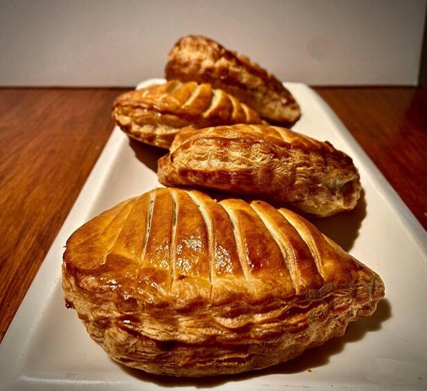 Three golden-brown pastries on a white plate. 2