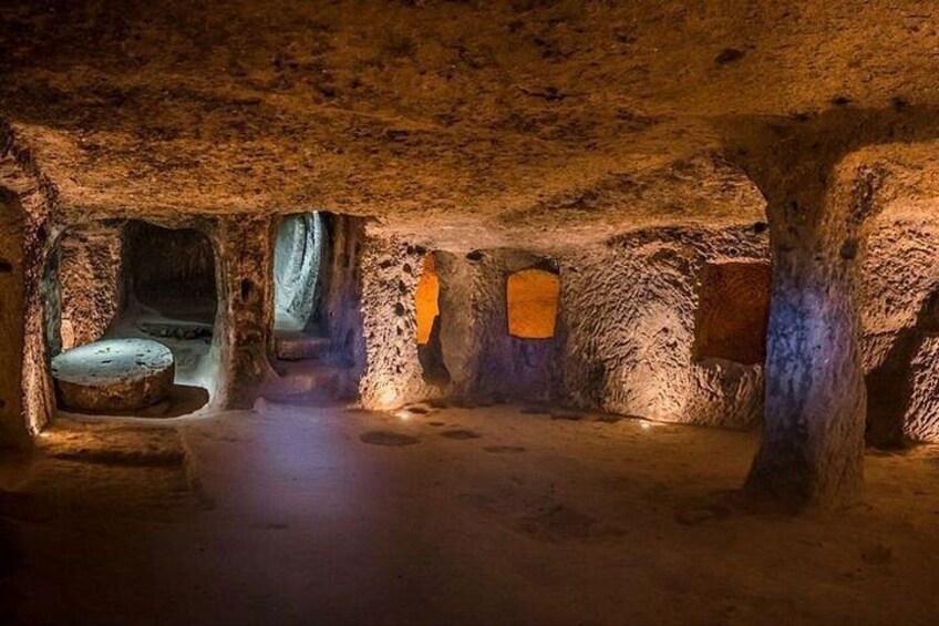 Una cueva con estalactitas, un banco de piedra y un pequeño ventanal. 1