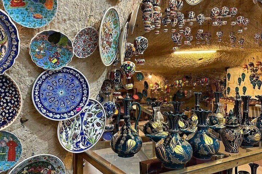 Una variedad de platos y jarrones de cerámica, con diseños intrincados, exhibidos en estantes y paredes. 3