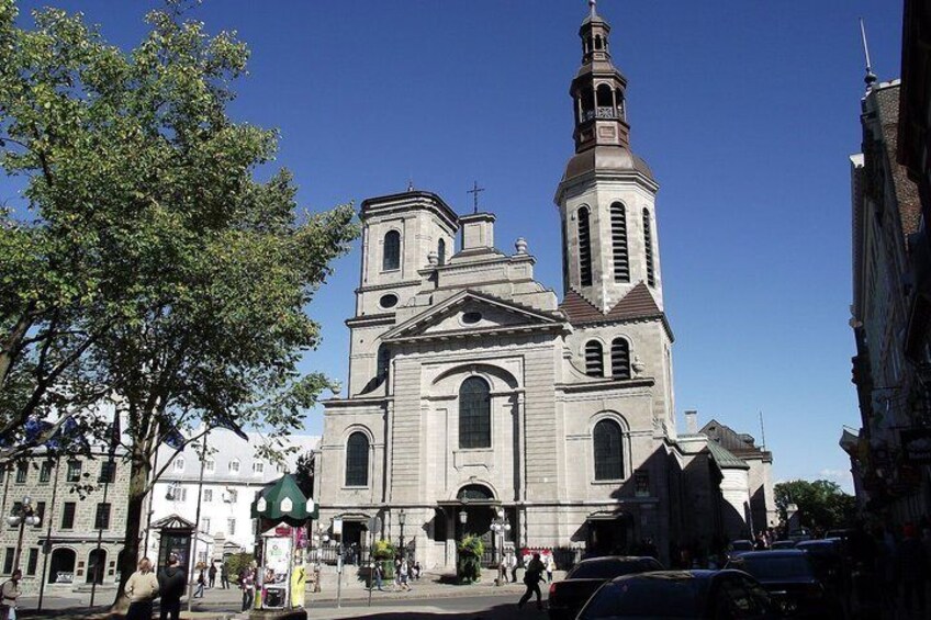 A historic church with a prominent bell tower and a large arched window. 4