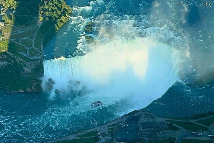 A large waterfall with a boat in the foreground. 4