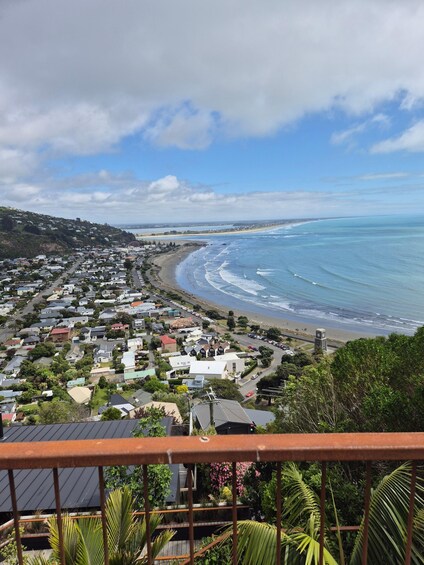 A coastal residential area with houses, a beach, and ocean waves. 1
