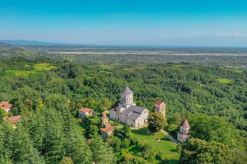 A church surrounded by dense forest and a clear sky. 2