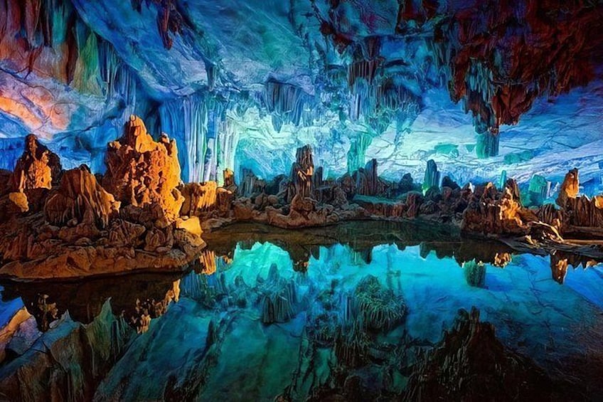 An ice cave with stalactites and stalagmites, a reflective pool, and a variety of ice formations. 5