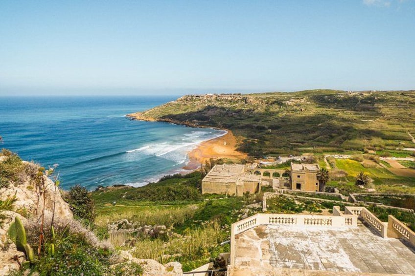 A coastal landscape with a beach, ruins, and a clear sky. 2