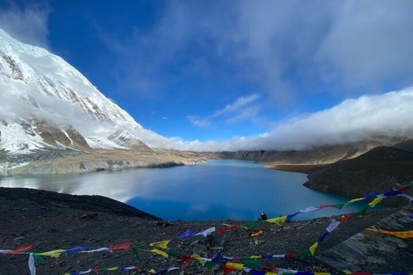 A snow-capped mountain, a clear blue lake, and colorful prayer flags. 1